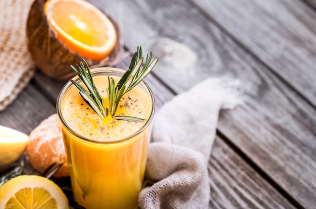 Woman holding orange juice with rosemary