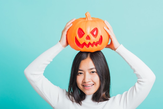 woman holding orange model pumpkins and put it on the head