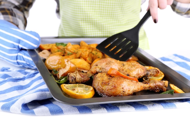 woman holding pan with homemade fried chicken and vegetables isolated on white
