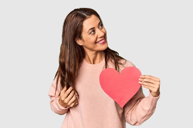 Woman holding paper heart for Valentines in studio