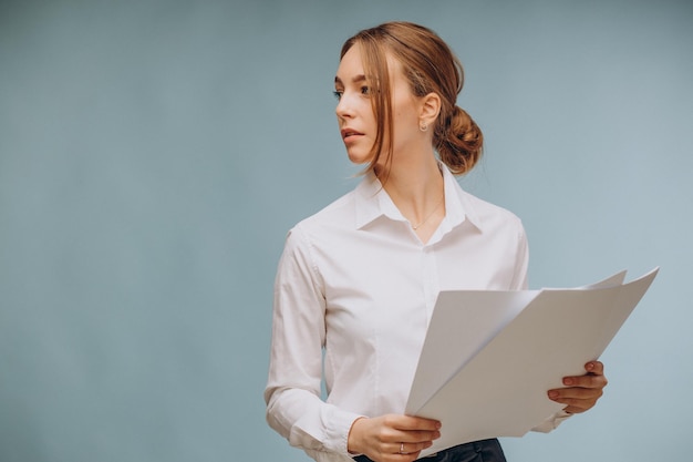 Woman holding papers , and standing isolated on blue