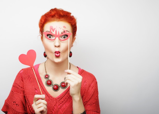 Woman holding a party heart and glasses.