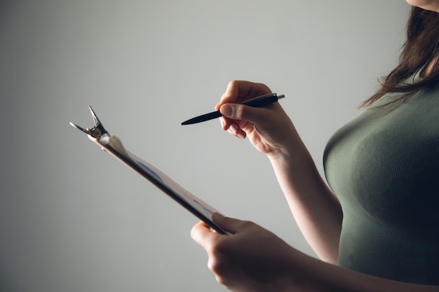 Photo woman holding pen with clipboard