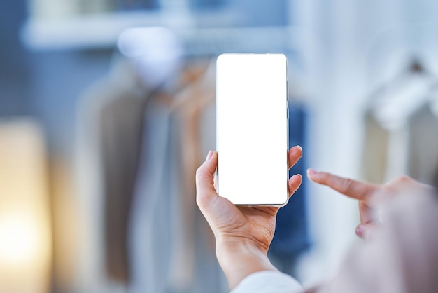 Woman holding phone in clothes store with blank space. High quality photo