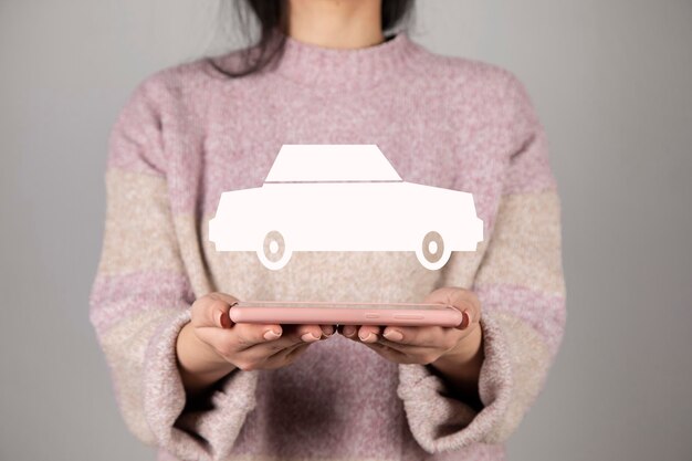 Foto telefono della tenuta della donna con l'icona dell'automobile