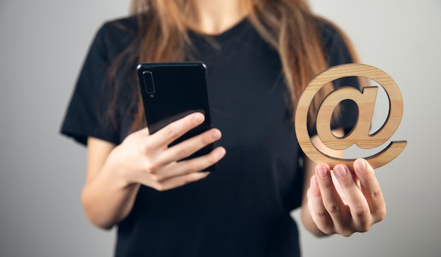 Woman holding phone with email sign.