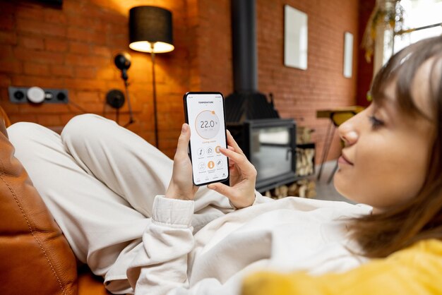 Photo woman holding phone with running smart home application for temperature control