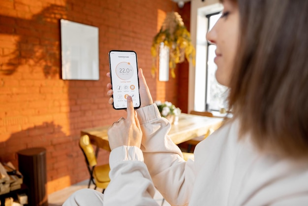 Woman holding phone with running smart home application