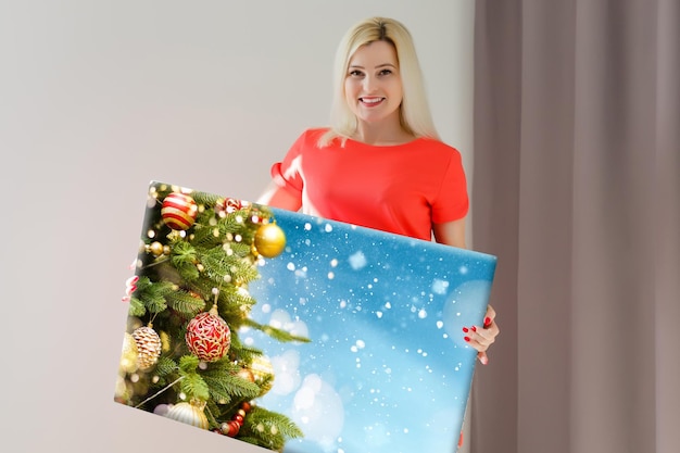 woman holding a photo canvas with a picture of christmas.