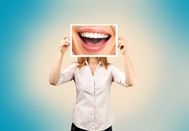 Woman holding picture with big smile. concept photo over dark background