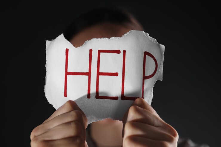 Photo woman holding piece of paper with word help on black background closeup domestic violence concept