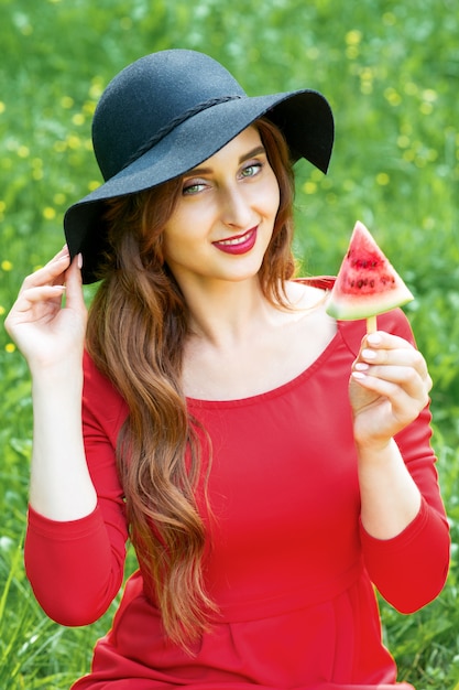 Woman holding piece of watermelon