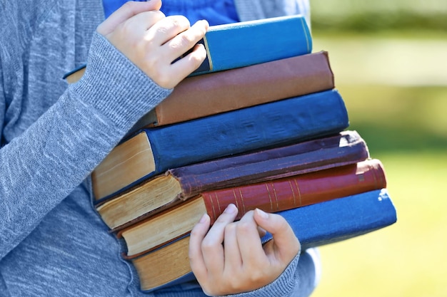 Foto donna che tiene una pila di libri da vicino