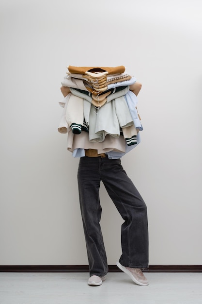 Woman holding pile of clothes