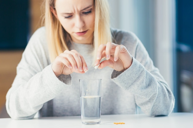 Foto donna con in mano pillole e bicchiere di acqua fresca fresh