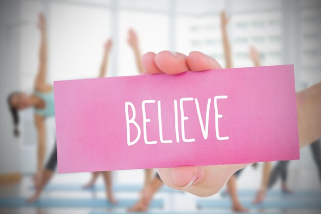 Photo woman holding pink card saying believe