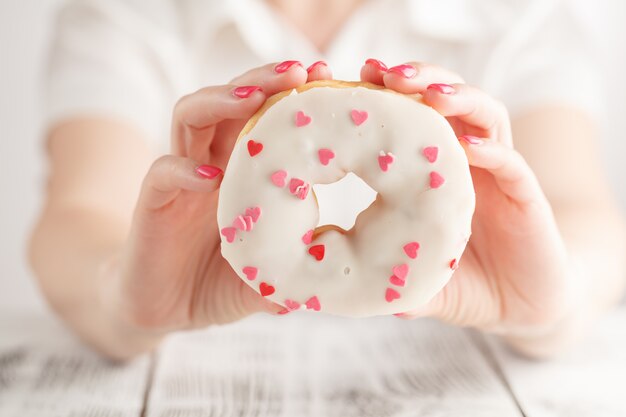 Donna che tiene una ciambella rosa