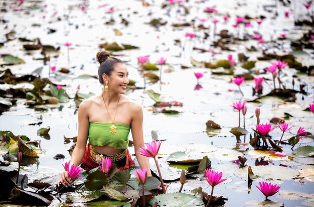 湖でピンクの花を保持している女性