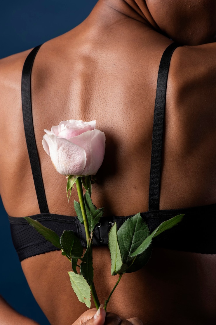 Photo woman holding a pink rose behind her back