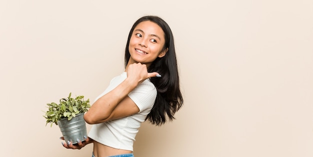 スタジオで植物を保持している女性