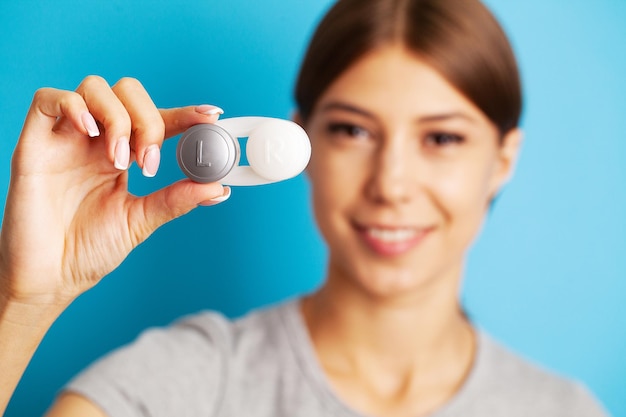 Woman holding plastic container with contact lenses