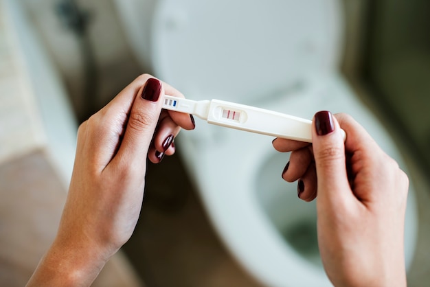 Photo woman holding a positive pregnancy test