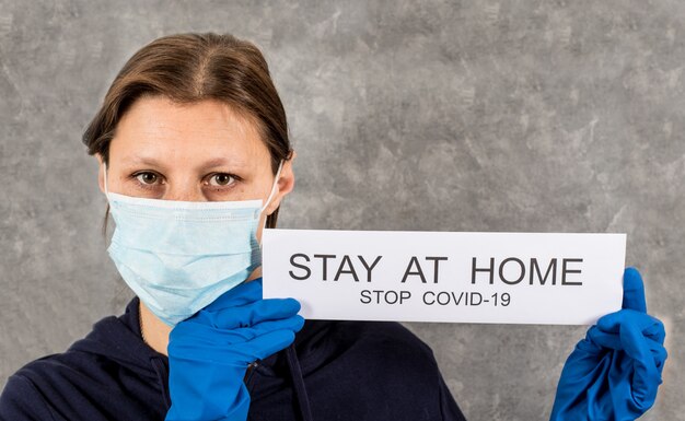 Woman holding poster with a massage " stay at home" to counter the spread of coronavirus