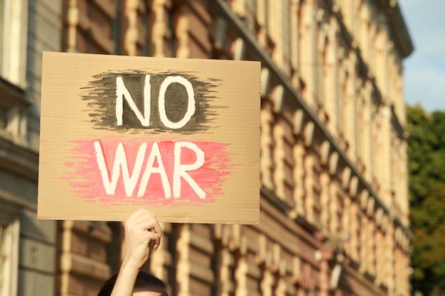 Photo woman holding poster with words no war outdoors space for text