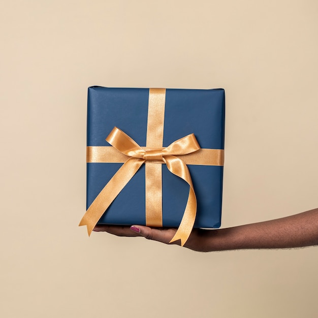 Woman holding a present against a beige background