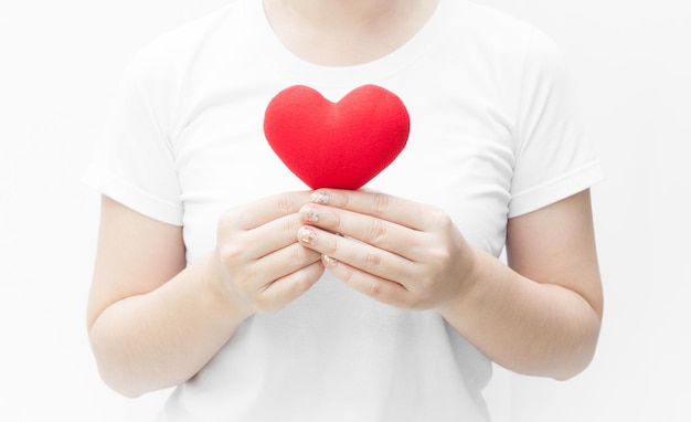 Woman holding and protecting a red heart shape on white background closeupSymbol of love or dating Valentines day