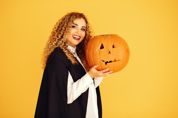 A woman holding a pumpkin that says halloween on it