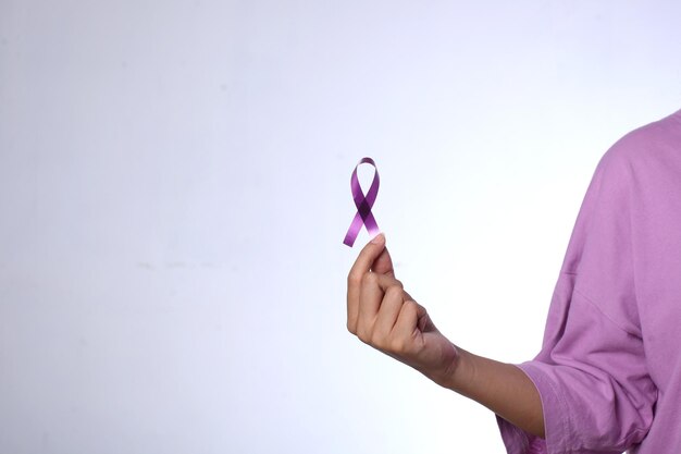 Woman holding a purple ribbon to commomerate cancer day