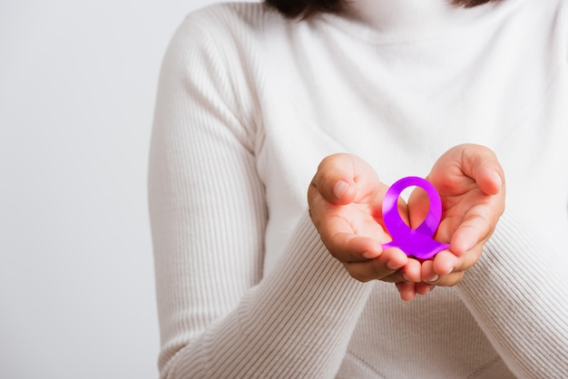 Woman holding purple ribbon in hands