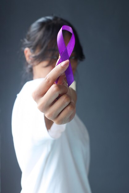 Photo woman holding purple ribbon symbol is used to raise awareness for alzheimer's disease epilepsy