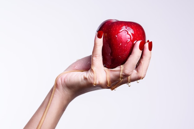 Una donna che tiene una mela rossa e acqua che scorre attraverso un concetto sano