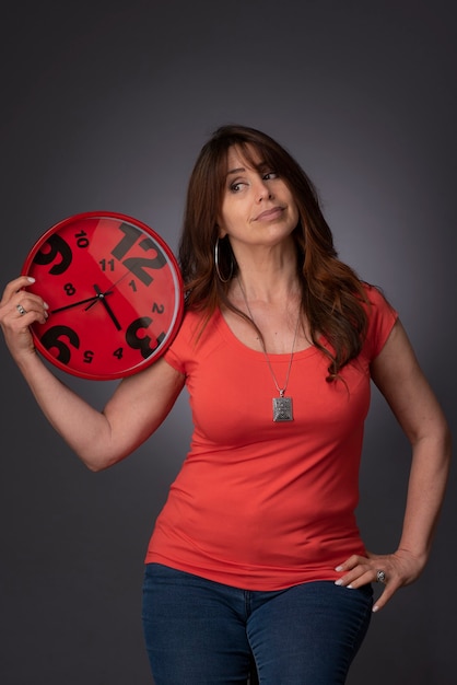 Photo woman holding a red clock