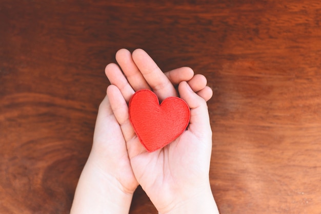 woman holding red heart on hands