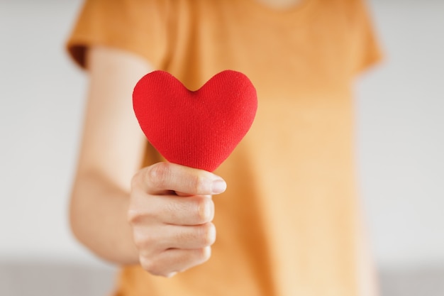 Woman holding red heart, love, health insurance, donation, happy charity volunteer, world mental health day, world heart day, valentine's day