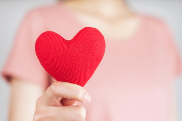 Woman holding red heart love health insurance donation valentines day