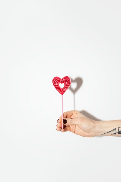 Woman holding a red heart on a stick