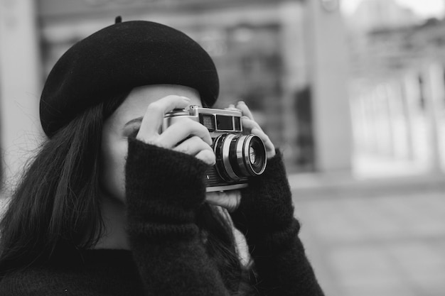 Woman holding retro camera and taking picture