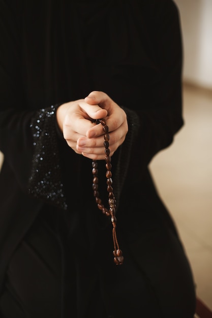 woman holding rosary and praying 