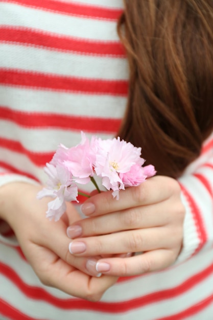 桜の花を手に持つ女性