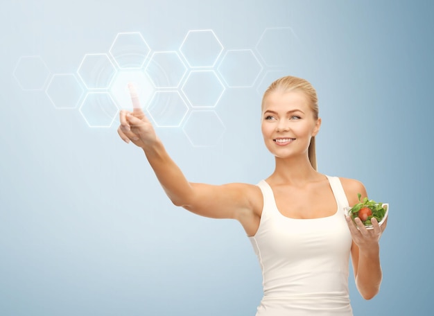 Photo woman holding salad and working with virtual screen