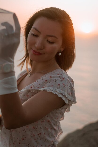 Foto donna con la sciarpa in piedi contro il cielo durante il tramonto