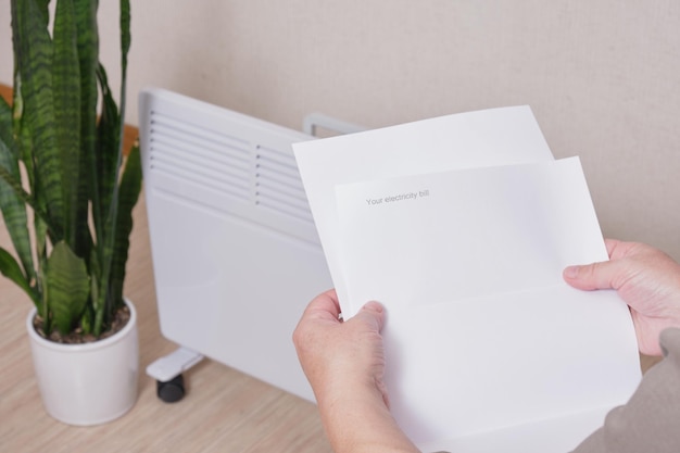 Woman holding a sheet of paper in her hands with an electricity bill