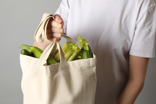 Женщина с сумкой с продуктовыми продуктами на светло-сером фоне крупного плана Эко-дружественный образ жизни