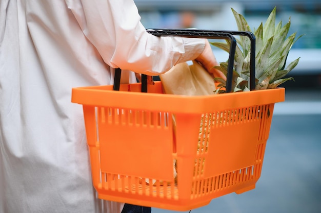 生鮮食品の買い物袋を持っている女性