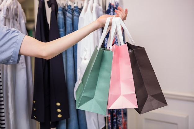 Woman holding shopping bags out