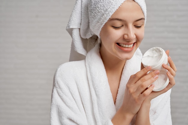 Woman holding and showing box with moisturizer for face